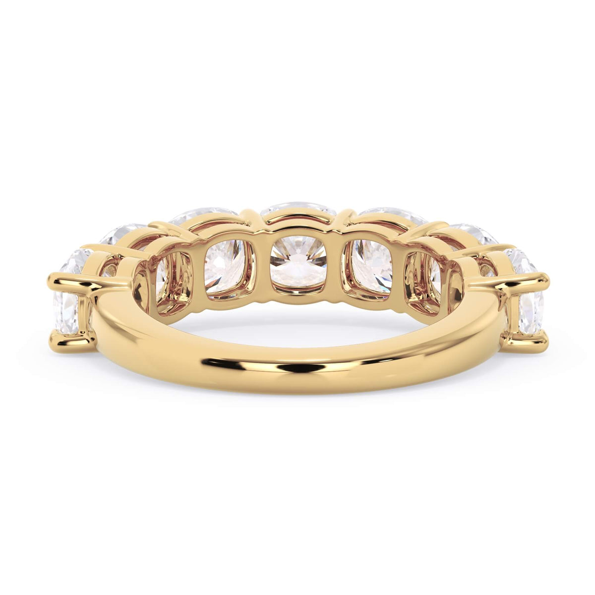 A picture of a seven stone diamond wedding ring with cushion cut diamonds that are shared prong set in yellow gold on a white background with a view of the underside of the ring.
