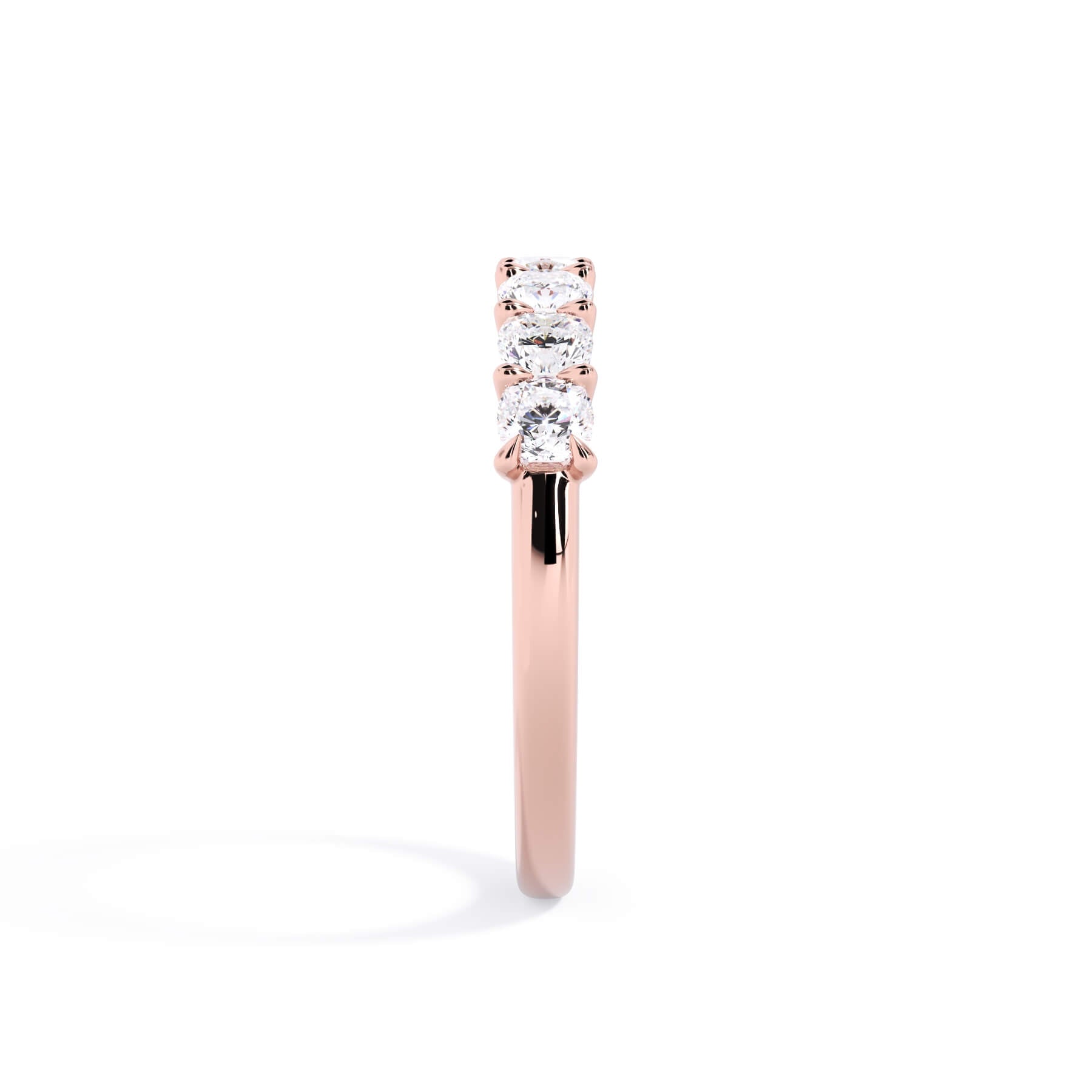 A picture of a seven stone diamond wedding ring with cushion cut diamonds that are U prong set in rose gold on a white background with a side profile view.