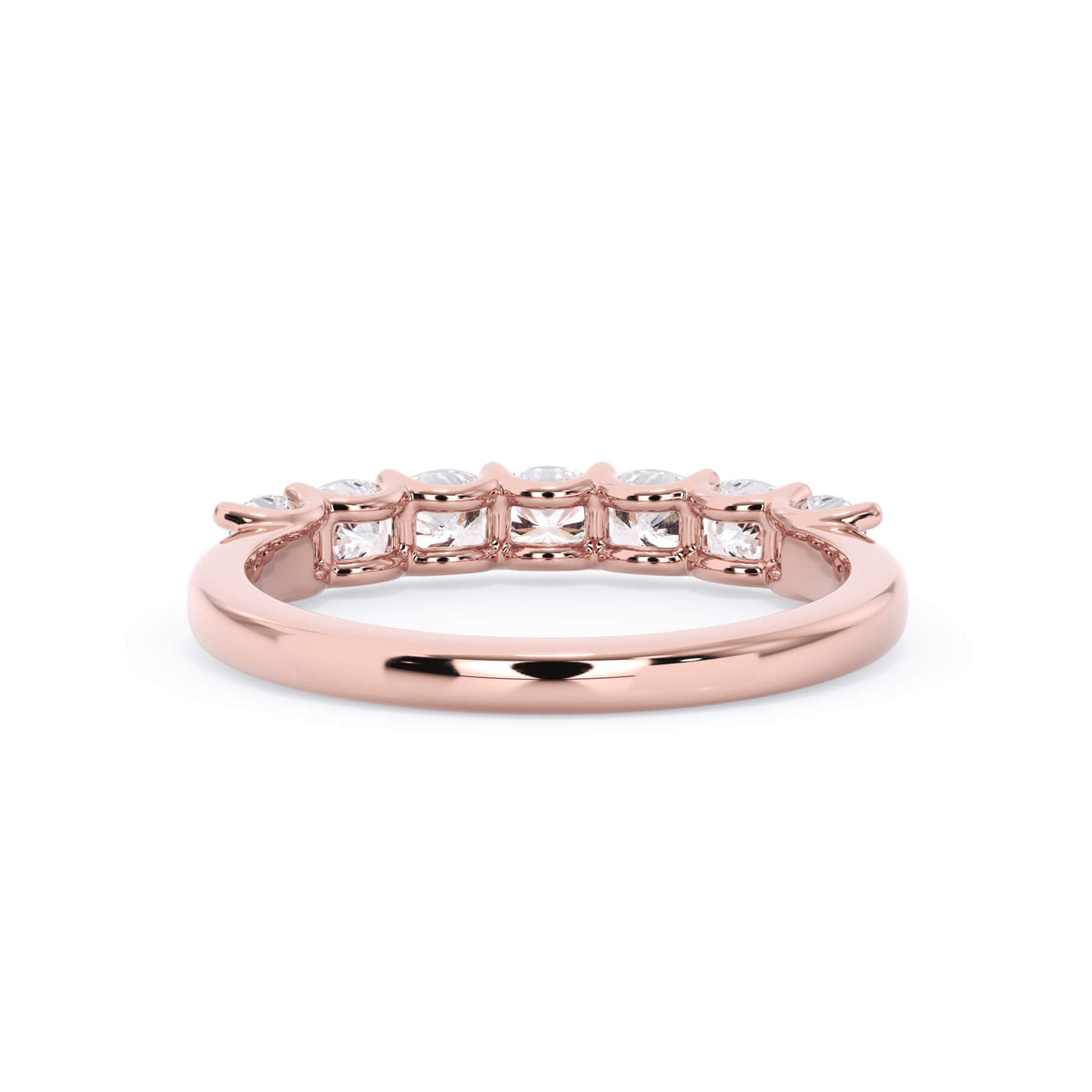 A picture of a seven stone diamond wedding ring with cushion cut diamonds that are U prong set in rose gold on a white background with a view of the underside of the ring.