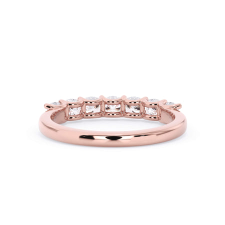A picture of a seven stone diamond wedding ring with cushion cut diamonds that are U prong set in rose gold on a white background with a view of the underside of the ring.
