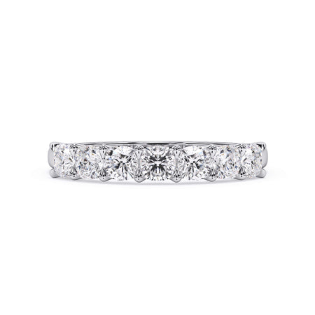 A picture of a seven stone diamond wedding ring with cushion cut diamonds that are U prong set in white gold or platinum on a white background with the ring facing forward, lying down.