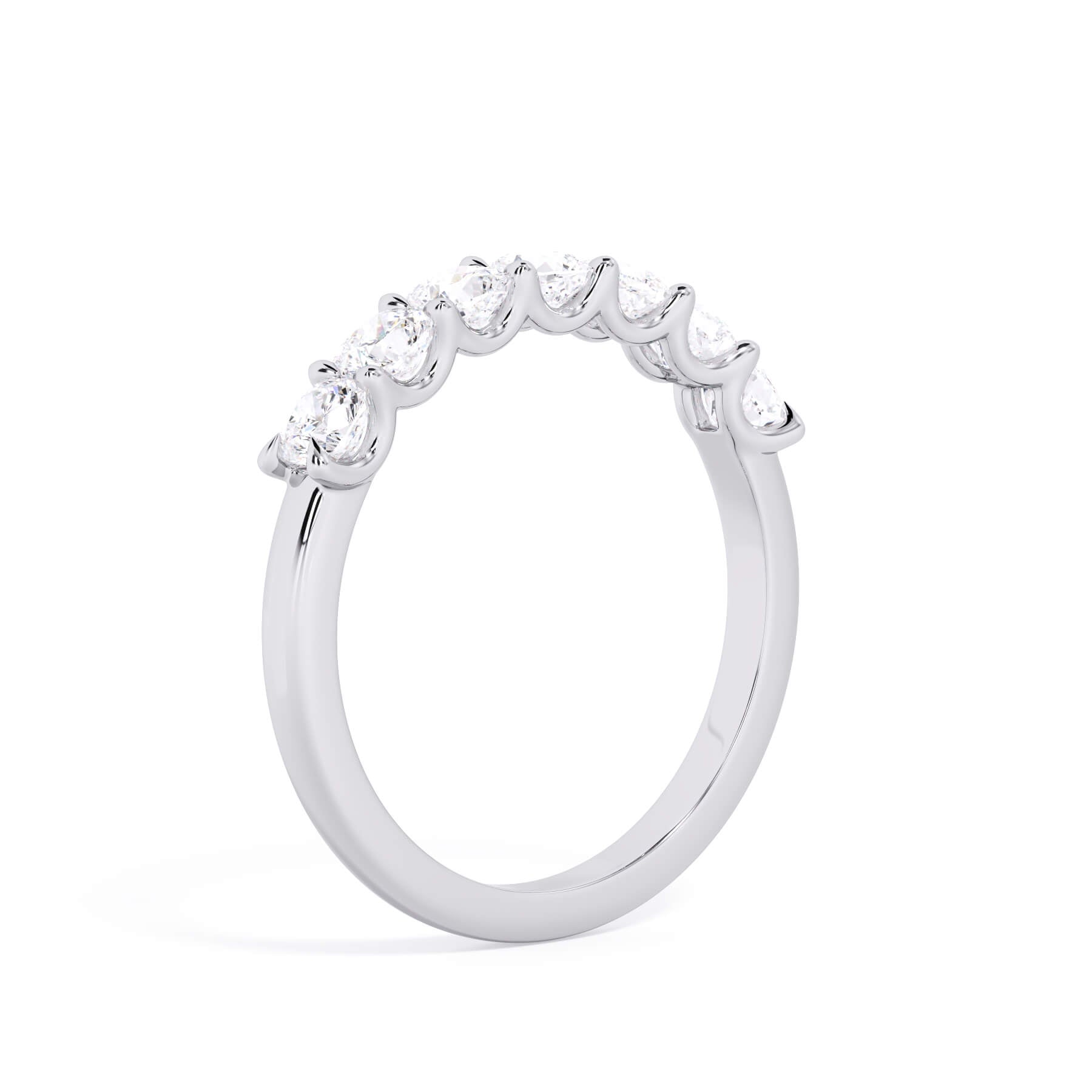 A picture of a seven stone diamond wedding ring with cushion cut diamonds that are U prong set in white gold or platinum on a white background with a slightly angled, through the finger view.