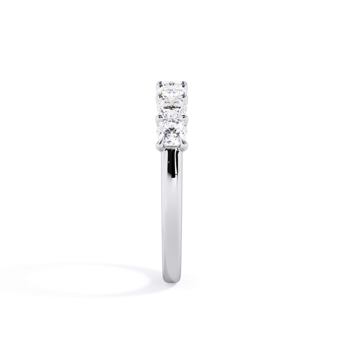 A picture of a seven stone diamond wedding ring with cushion cut diamonds that are U prong set in white gold or platinum on a white background with a side profile view.