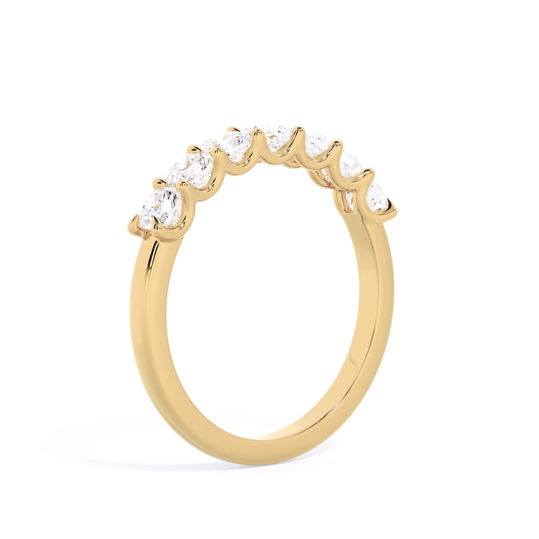 A picture of a seven stone diamond wedding ring with cushion cut diamonds that are U prong set in yellow gold on a white background with a slightly angled, through the finger view.
