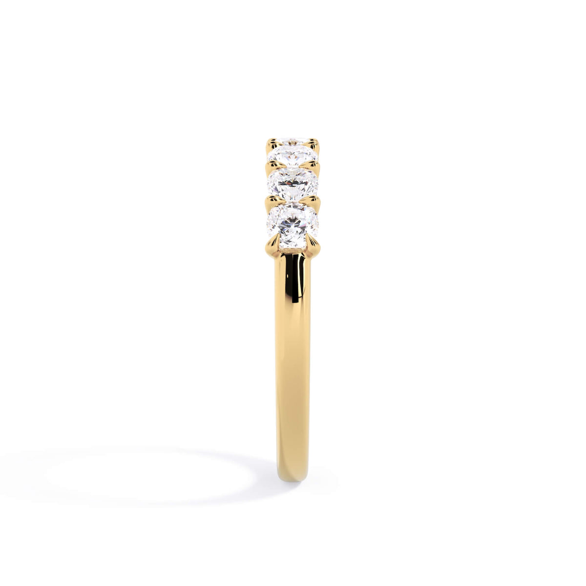 A picture of a seven stone diamond wedding ring with cushion cut diamonds that are U prong set in yellow gold on a white background with a side profile view.