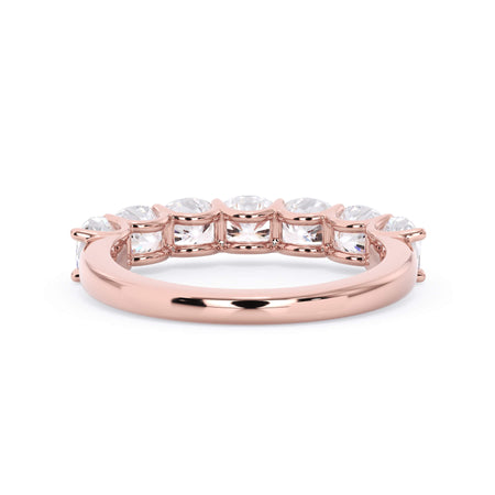 A picture of a seven stone diamond wedding ring with cushion cut diamonds that are U prong set in rose gold on a white background with a view of the underside of the ring.