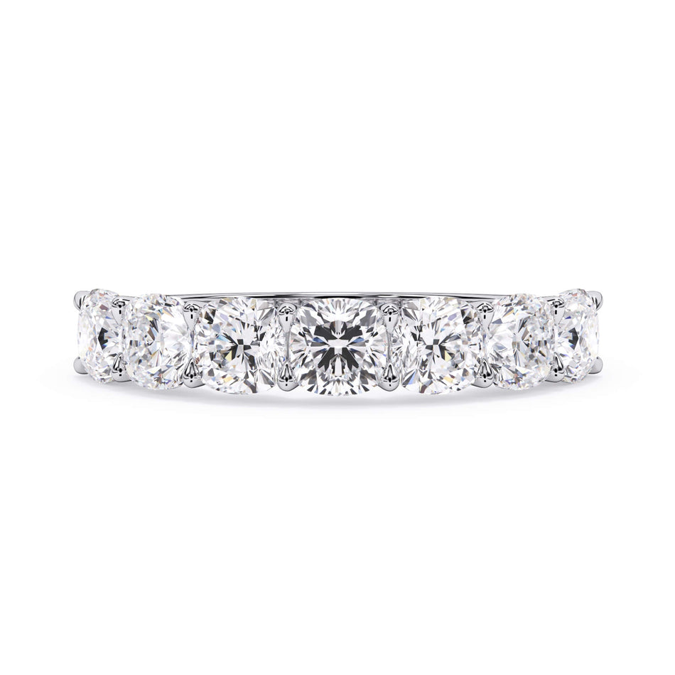 A picture of a seven stone diamond wedding ring with cushion cut diamonds that are U prong set in white gold or platinum on a white background with the ring facing forward, lying down.