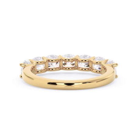 A picture of a seven stone diamond wedding ring with cushion cut diamonds that are U prong set in yellow gold on a white background with a view of the underside of the ring.