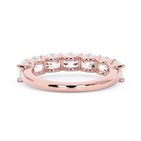A picture of a seven stone diamond wedding ring with cushion cut diamonds that are U prong set in rose gold on a white background with a view of the underside of the ring.