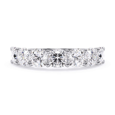 A picture of a seven stone diamond wedding ring with cushion cut diamonds that are U prong set in white gold or platinum on a white background with the ring facing forward, lying down.