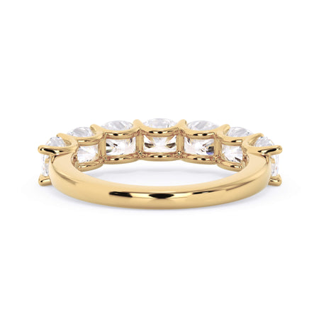 A picture of a seven stone diamond wedding ring with cushion cut diamonds that are U prong set in yellow gold on a white background with a view of the underside of the ring.