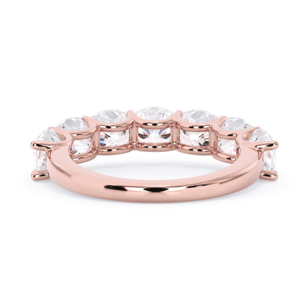 A picture of a seven stone diamond wedding ring with cushion cut diamonds that are U prong set in rose gold on a white background with a view of the underside of the ring.