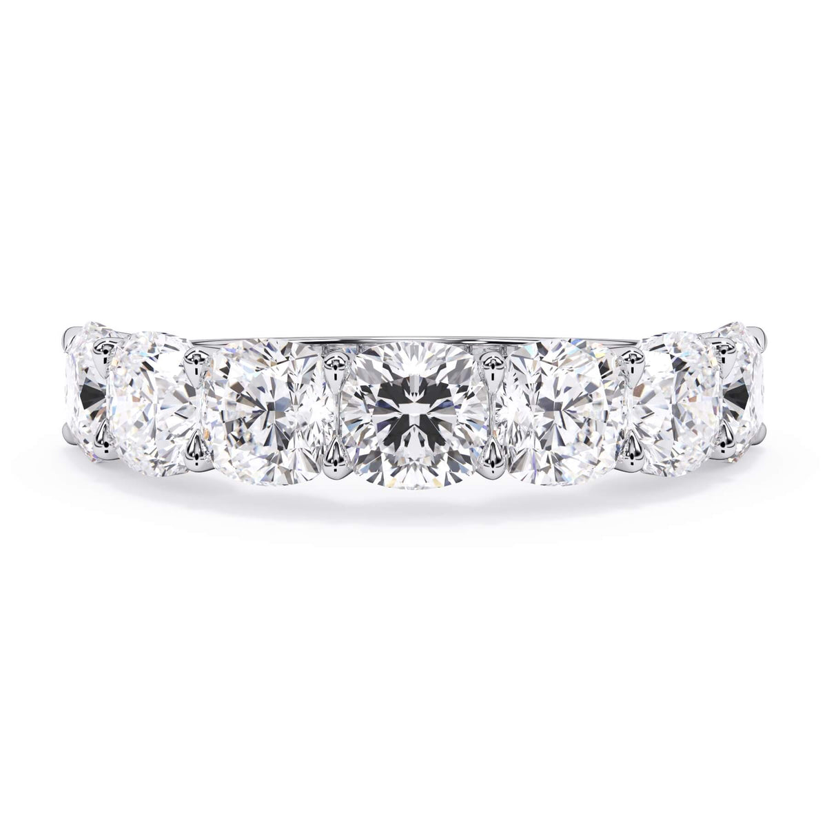A picture of a seven stone diamond wedding ring with cushion cut diamonds that are U prong set in white gold or platinum on a white background with the ring facing forward, lying down.