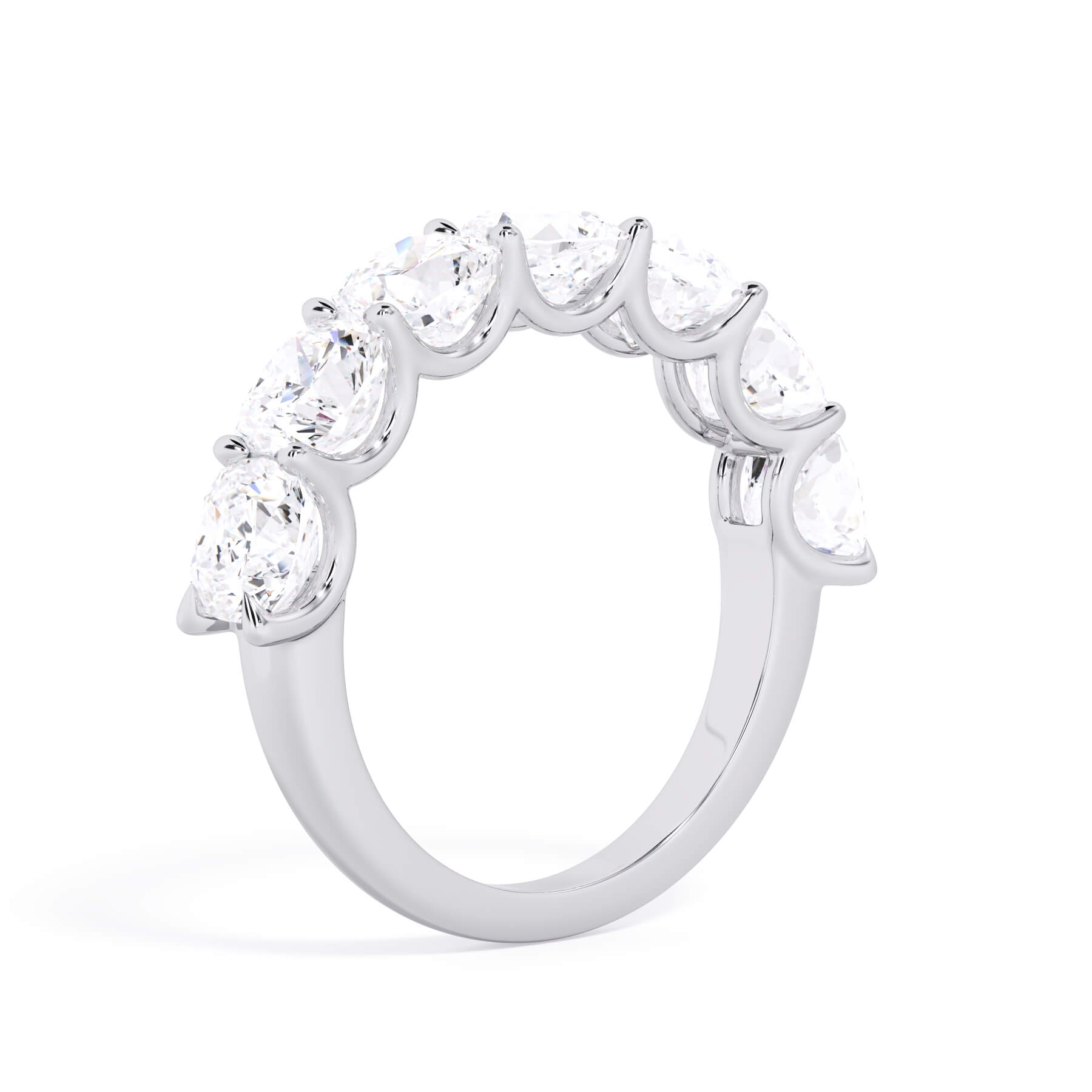 A picture of a seven stone diamond wedding ring with cushion cut diamonds that are U prong set in white gold or platinum on a white background with a slightly angled, through the finger view.