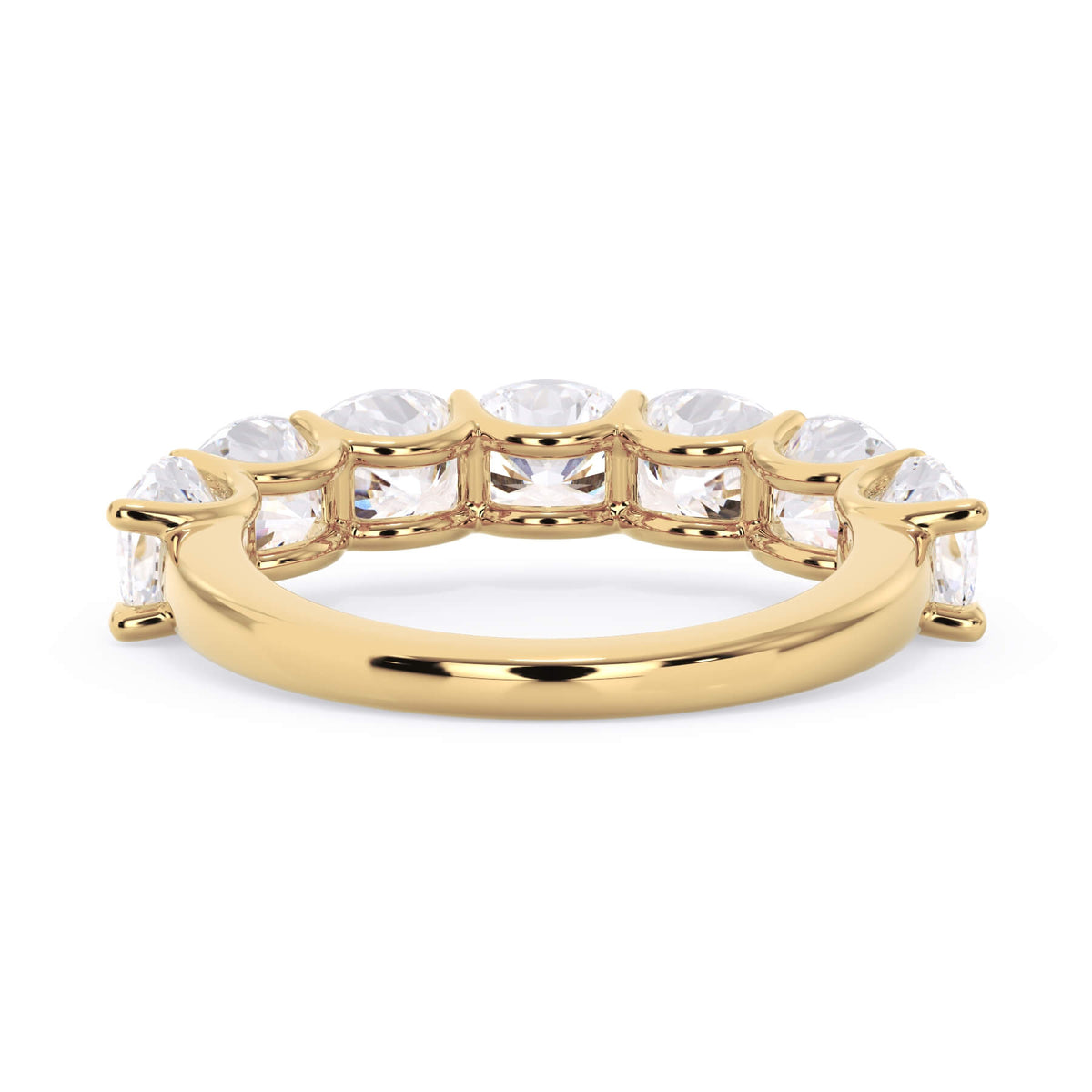 A picture of a seven stone diamond wedding ring with cushion cut diamonds that are U prong set in yellow gold on a white background with a view of the underside of the ring.