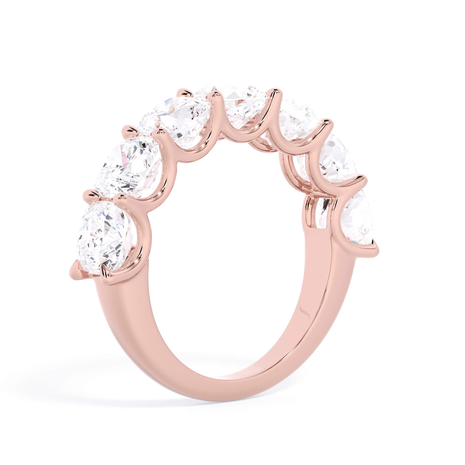 A picture of a seven stone diamond wedding ring with cushion cut diamonds that are U prong set in rose gold on a white background with a slightly angled, through the finger view.