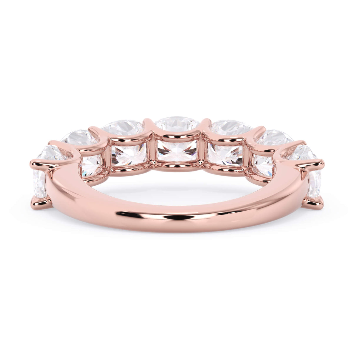 A picture of a seven stone diamond wedding ring with cushion cut diamonds that are U prong set in rose gold on a white background with a view of the underside of the ring.