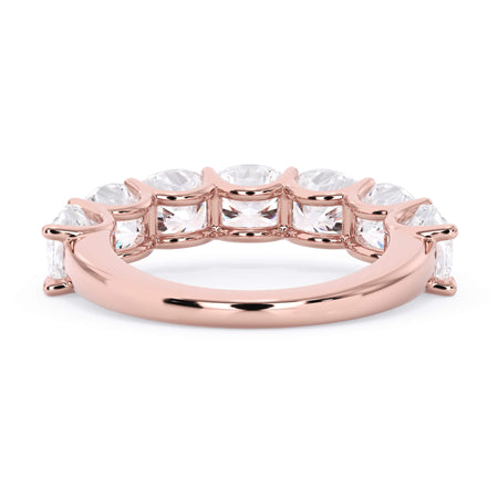 A picture of a seven stone diamond wedding ring with cushion cut diamonds that are U prong set in rose gold on a white background with a view of the underside of the ring.
