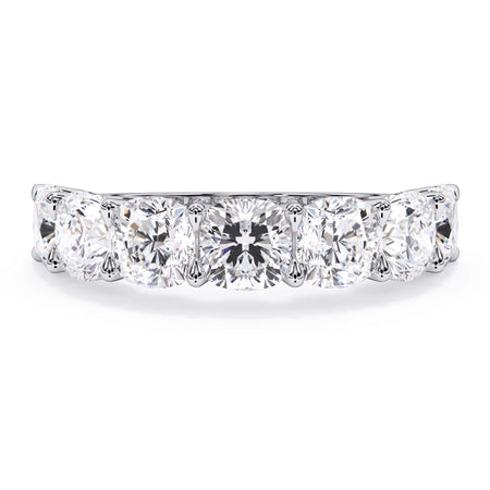 A picture of a seven stone diamond wedding ring with cushion cut diamonds that are U prong set in white gold or platinum on a white background with the ring facing forward, lying down.