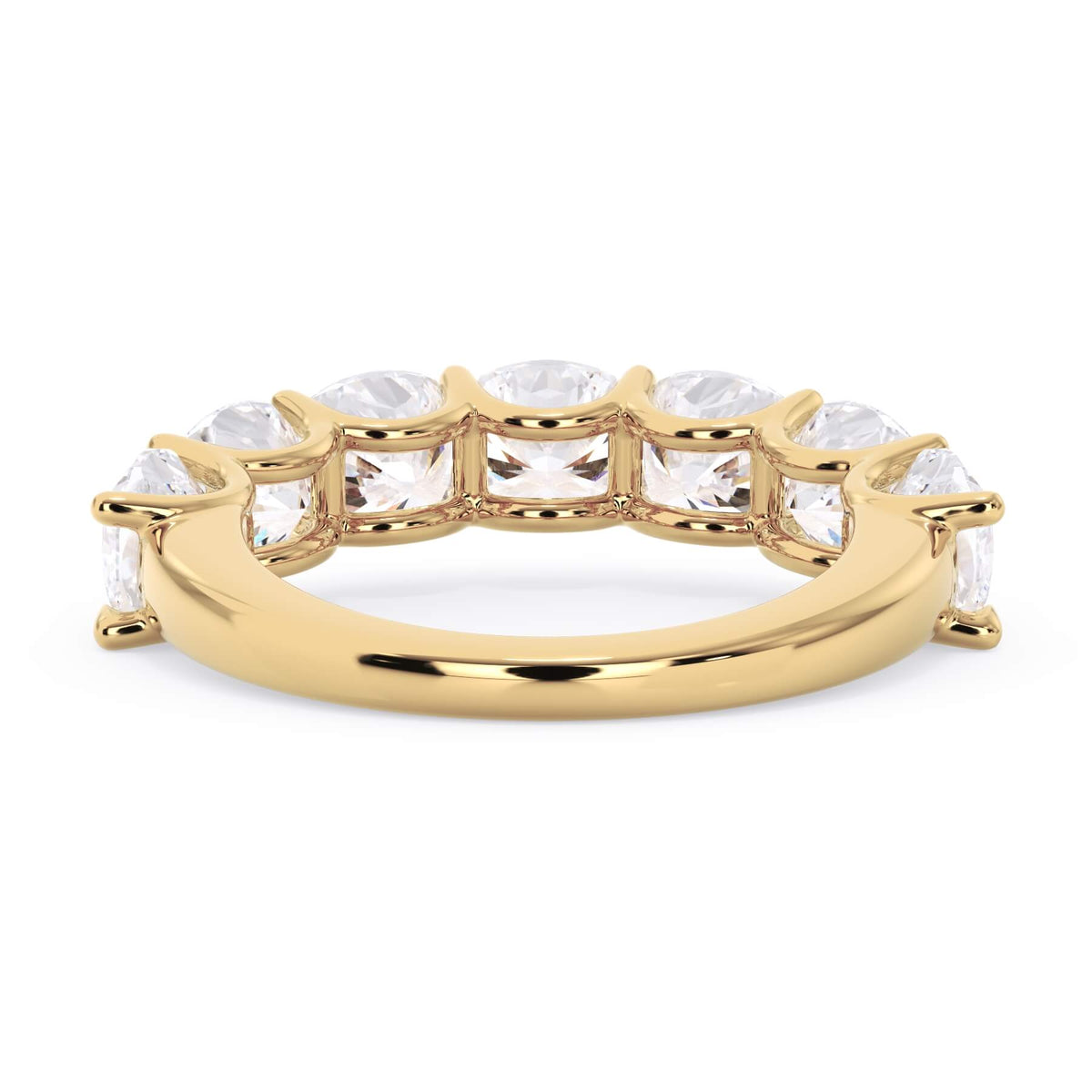 A picture of a seven stone diamond wedding ring with cushion cut diamonds that are U prong set in yellow gold on a white background with a view of the underside of the ring.