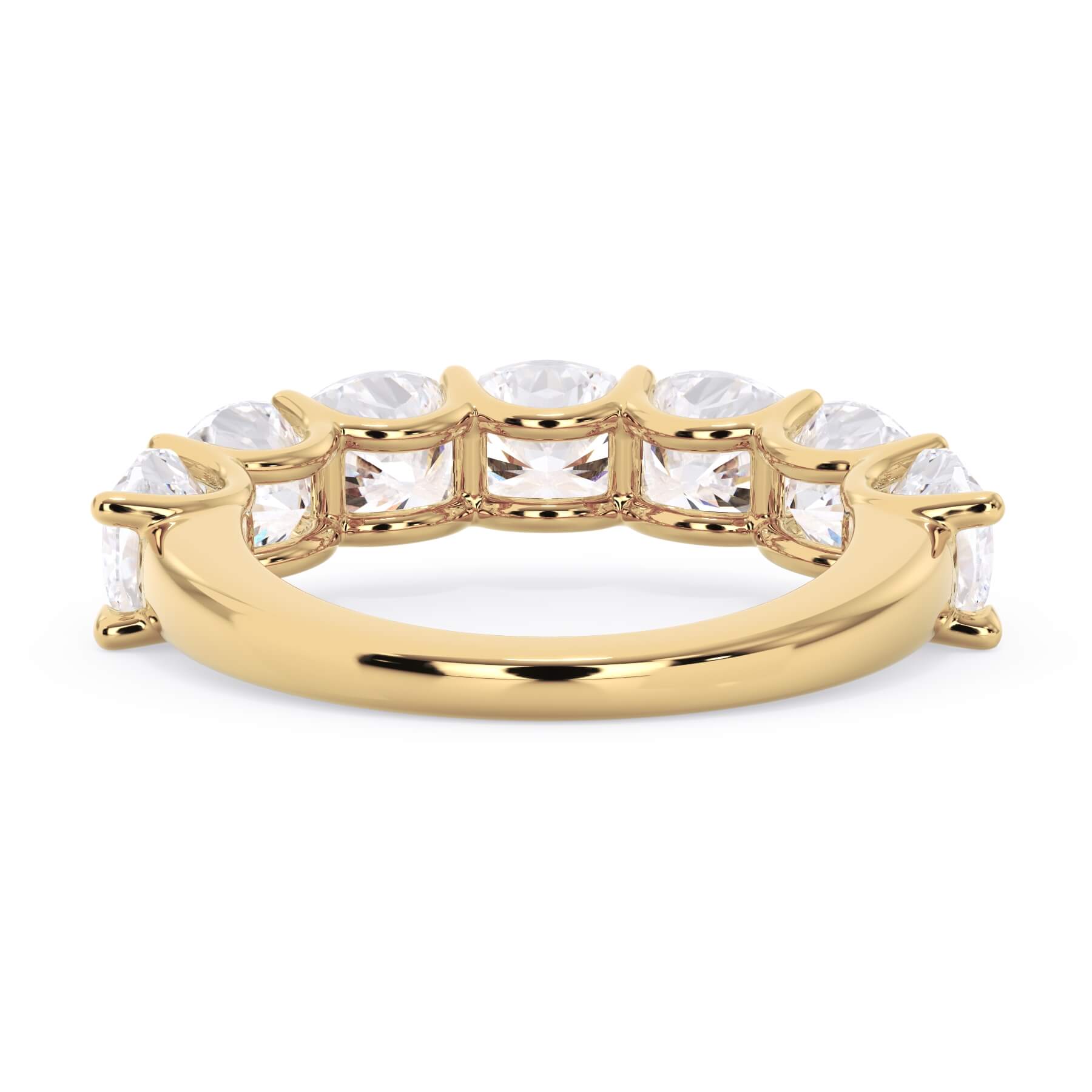 A picture of a seven stone diamond wedding ring with cushion cut diamonds that are U prong set in yellow gold on a white background with a view of the underside of the ring.