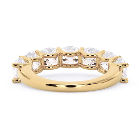 A picture of a seven stone diamond wedding ring with cushion cut diamonds that are U prong set in yellow gold on a white background with a view of the underside of the ring.