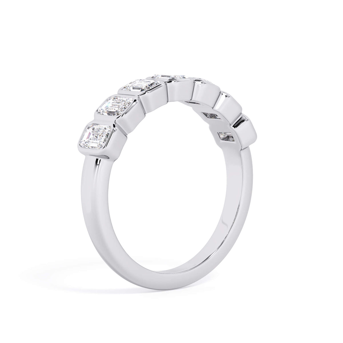 A picture of a seven stone diamond wedding ring with emerald cut diamonds that are bezel set in white gold or platinum on a white background with a slightly angled, through the finger view.