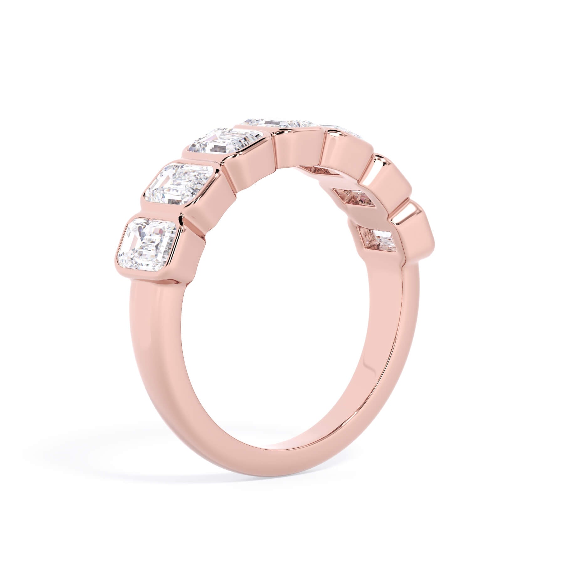 A picture of a seven stone diamond wedding ring with emerald cut diamonds that are bezel set in rose gold on a white background with a slightly angled, through the finger view.