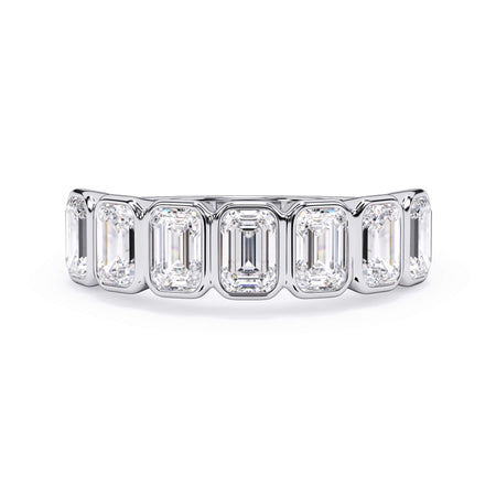 A picture of a seven stone diamond wedding ring with emerald cut diamonds that are bezel set in white gold or platinum on a white background with the ring facing forward, lying down.