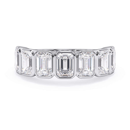 A picture of a seven stone diamond wedding ring with emerald cut diamonds that are bezel set in white gold or platinum on a white background with the ring facing forward, lying down.