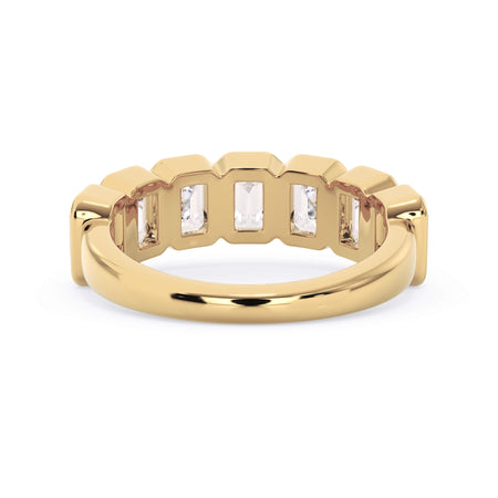 A picture of a seven stone diamond wedding ring with emerald cut diamonds that are bezel set in yellow gold on a white background with a view of the underside of the ring.