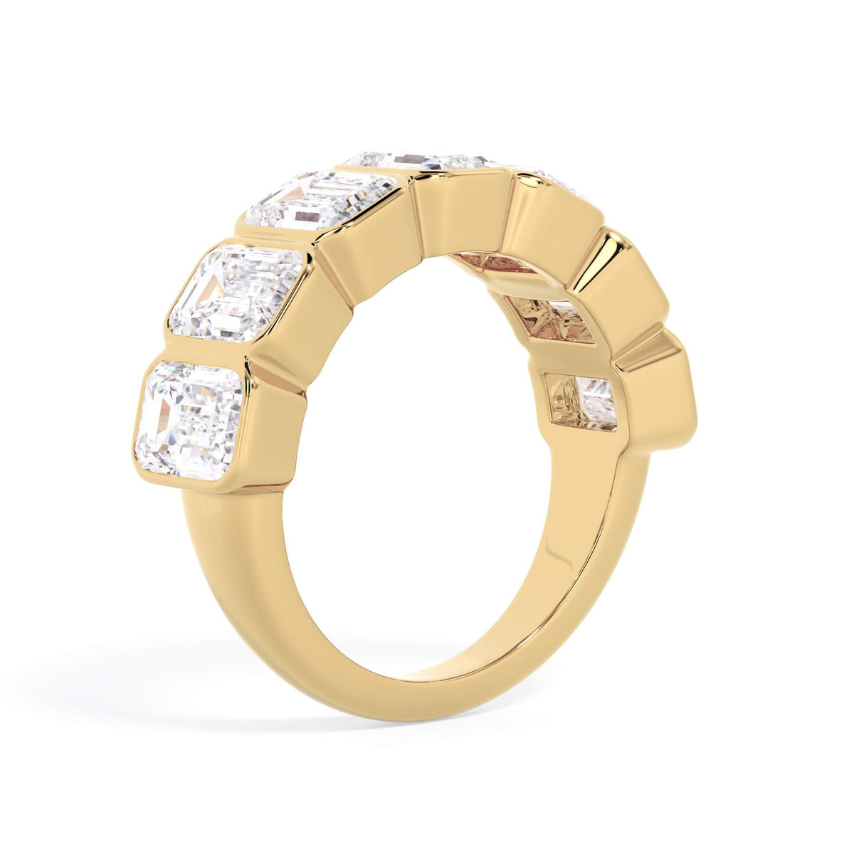 A picture of a seven stone diamond wedding ring with emerald cut diamonds that are bezel set in yellow gold on a white background with a slightly angled, through the finger view.