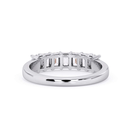 A picture of a seven stone diamond wedding ring with emerald cut diamonds that are shared prong set in white gold or platinum on a white background with a view of the underside of the ring.