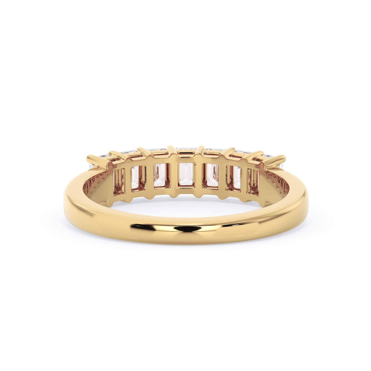 A picture of a seven stone diamond wedding ring with emerald cut diamonds that are shared prong set in yellow gold on a white background with a view of the underside of the ring.