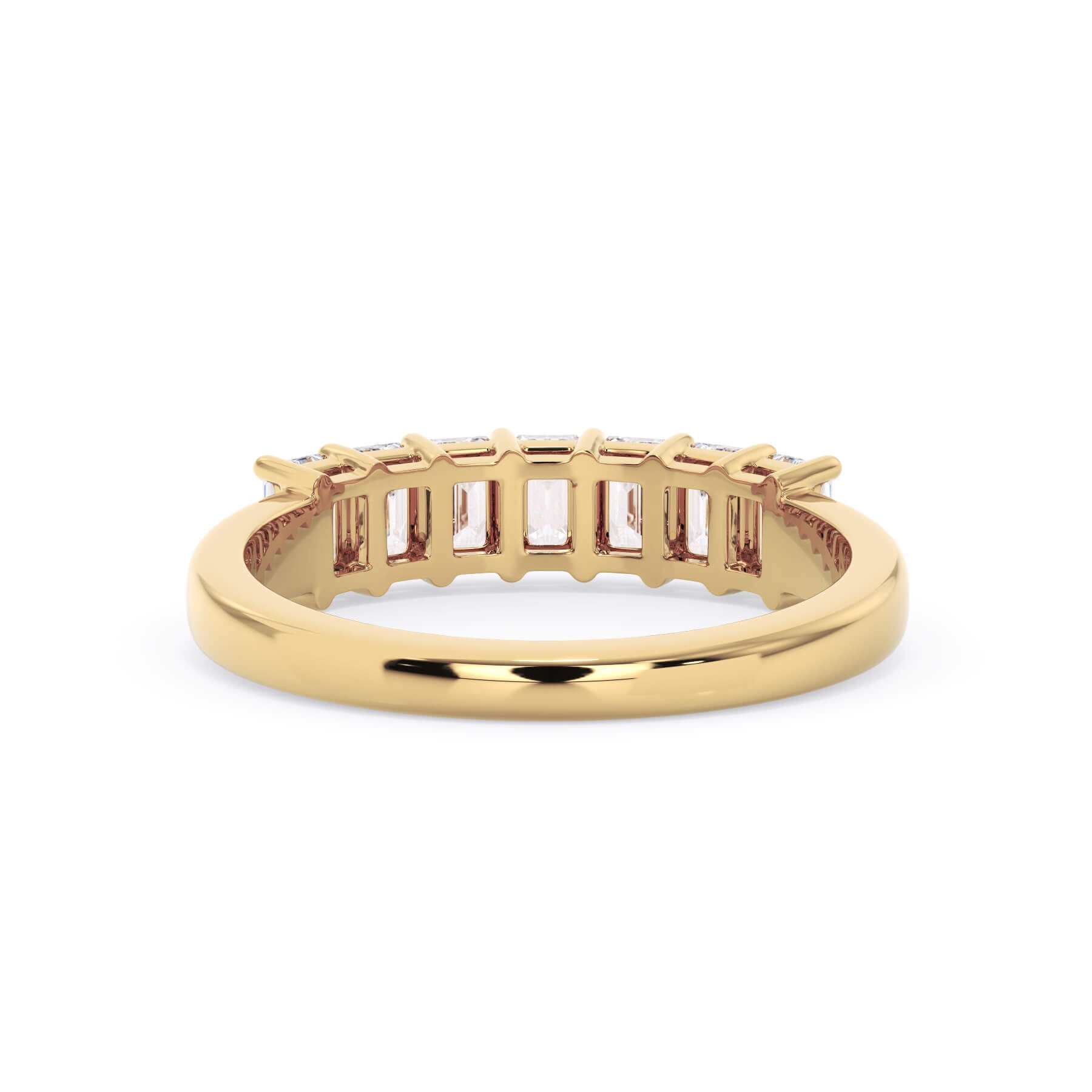 A picture of a seven stone diamond wedding ring with emerald cut diamonds that are shared prong set in yellow gold on a white background with a view of the underside of the ring.