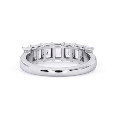 A picture of a seven stone diamond wedding ring with emerald cut diamonds that are shared prong set in white gold or platinum on a white background with a view of the underside of the ring.