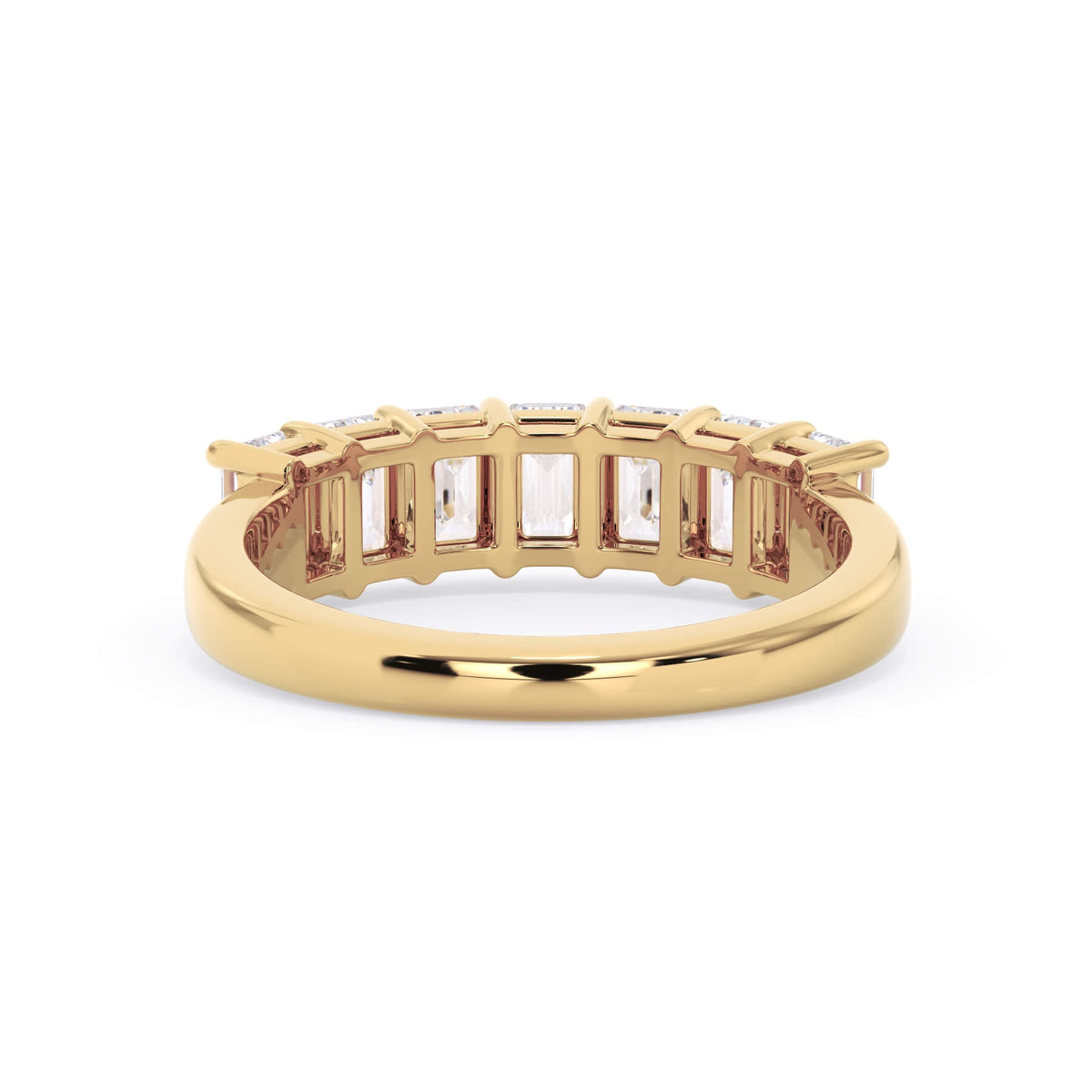 A picture of a seven stone diamond wedding ring with emerald cut diamonds that are shared prong set in yellow gold on a white background with a view of the underside of the ring.