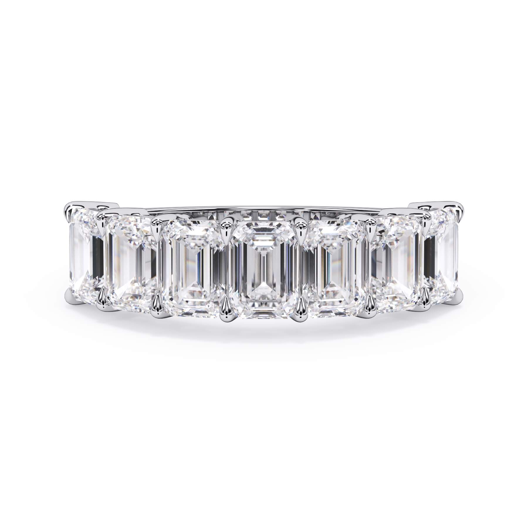 A picture of a seven stone diamond wedding ring with emerald cut diamonds that are shared prong set in white gold or platinum on a white background with the ring facing forward, lying down.