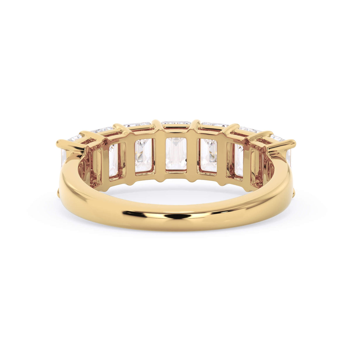A picture of a seven stone diamond wedding ring with emerald cut diamonds that are shared prong set in yellow gold on a white background with a view of the underside of the ring.