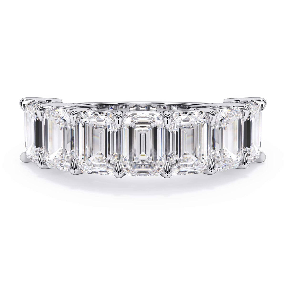 A picture of a seven stone diamond wedding ring with emerald cut diamonds that are shared prong set in white gold or platinum on a white background with the ring facing forward, lying down.