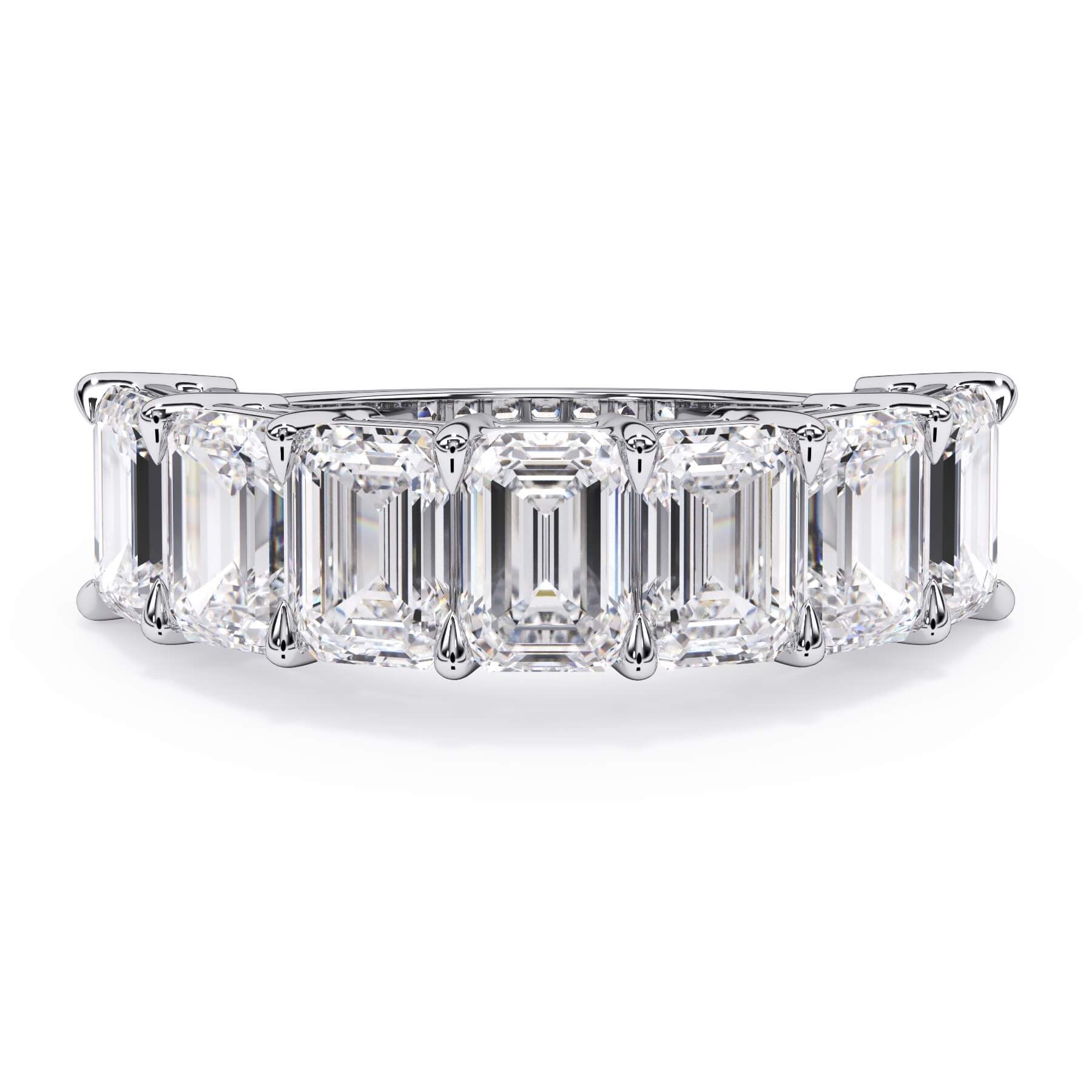 A picture of a seven stone diamond wedding ring with emerald cut diamonds that are shared prong set in white gold or platinum on a white background with the ring facing forward, lying down.