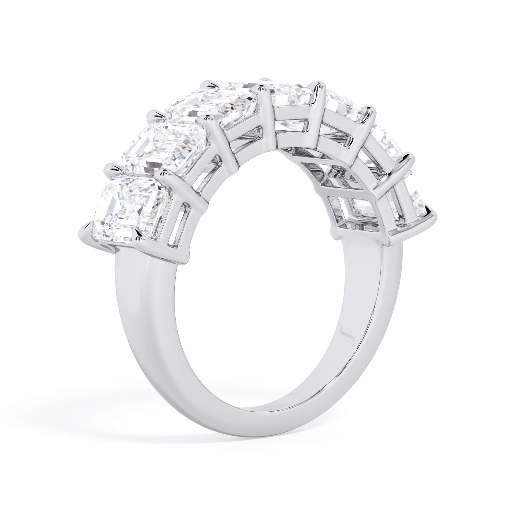 A picture of a seven stone diamond wedding ring with emerald cut diamonds that are shared prong set in white gold or platinum on a white background with a slightly angled, through the finger view.