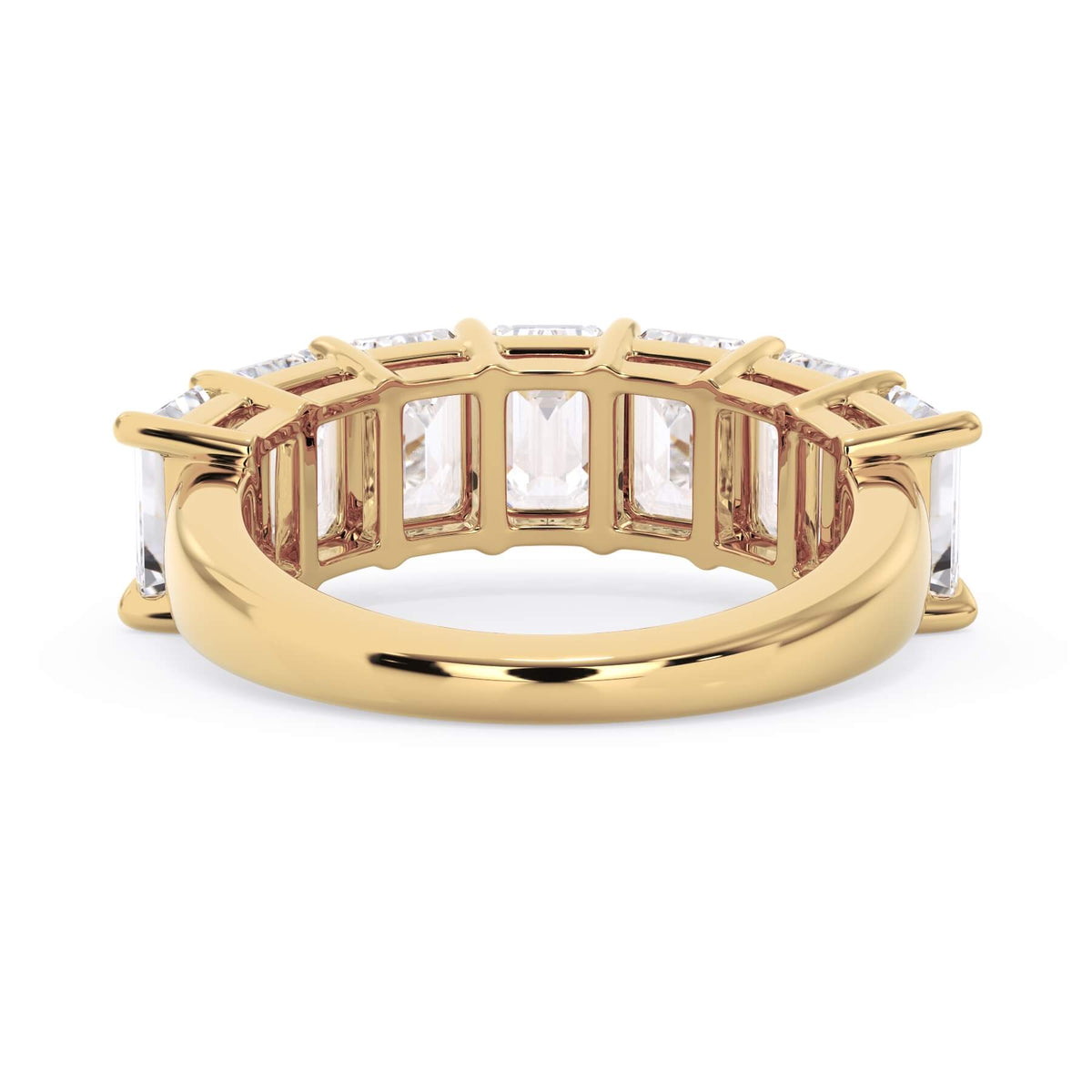 A picture of a seven stone diamond wedding ring with emerald cut diamonds that are shared prong set in yellow gold on a white background with a view of the underside of the ring.