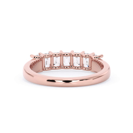 A picture of a seven stone diamond wedding ring with emerald cut diamonds that are U prong set in rose gold on a white background with a view of the underside of the ring.