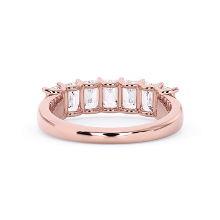A picture of a seven stone diamond wedding ring with emerald cut diamonds that are U prong set in rose gold on a white background with a view of the underside of the ring.