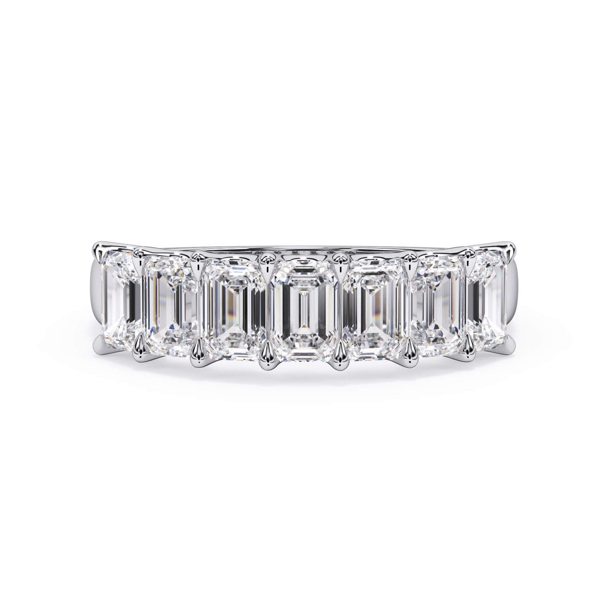 A picture of a seven stone diamond wedding ring with emerald cut diamonds that are U prong set in white gold or platinum on a white background with the ring facing forward, lying down.