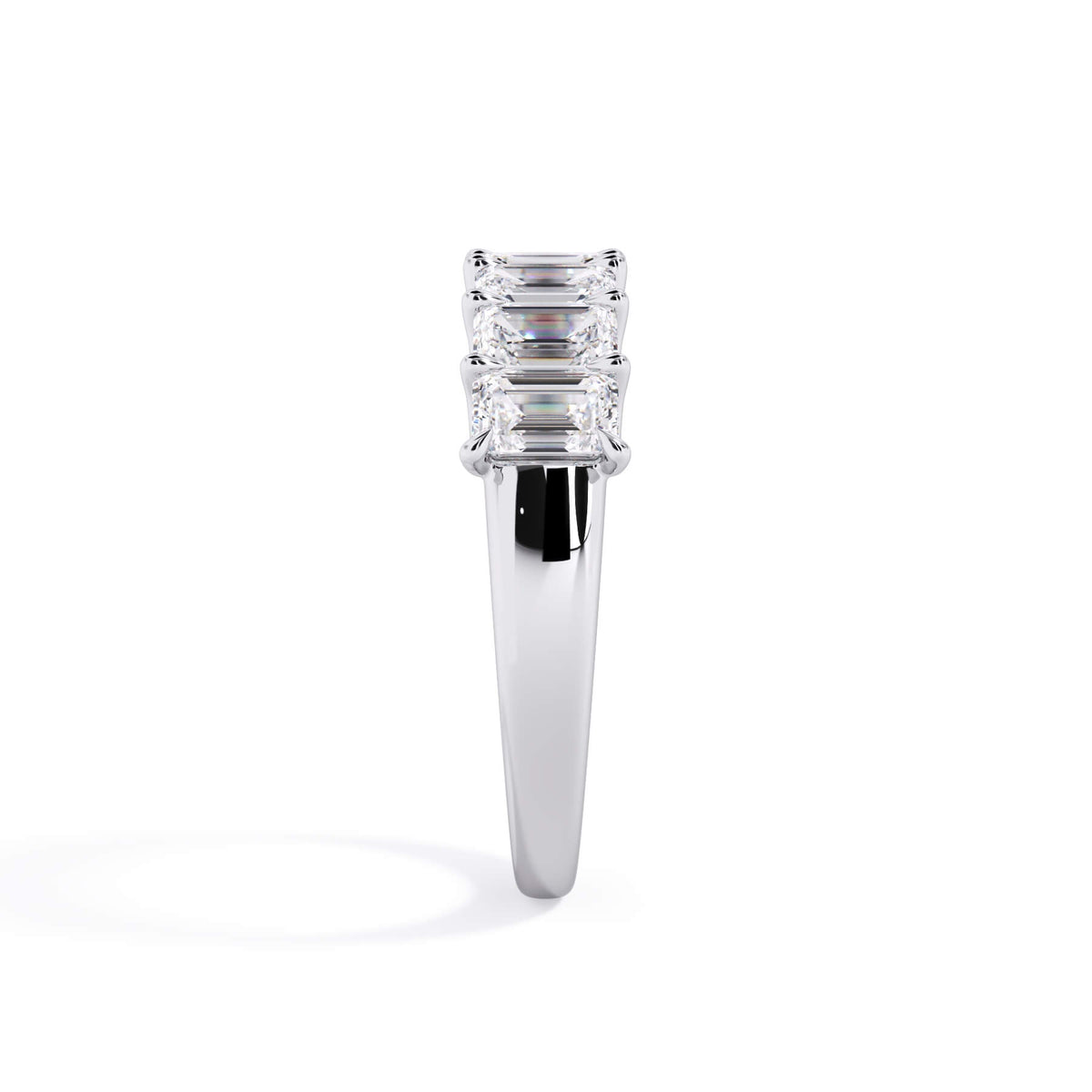 A picture of a seven stone diamond wedding ring with emerald cut diamonds that are U prong set in white gold or platinum on a white background with a side profile view.