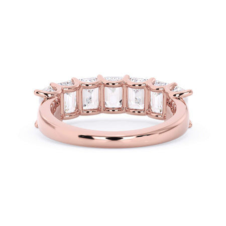 A picture of a seven stone diamond wedding ring with emerald cut diamonds that are U prong set in rose gold on a white background with a view of the underside of the ring.