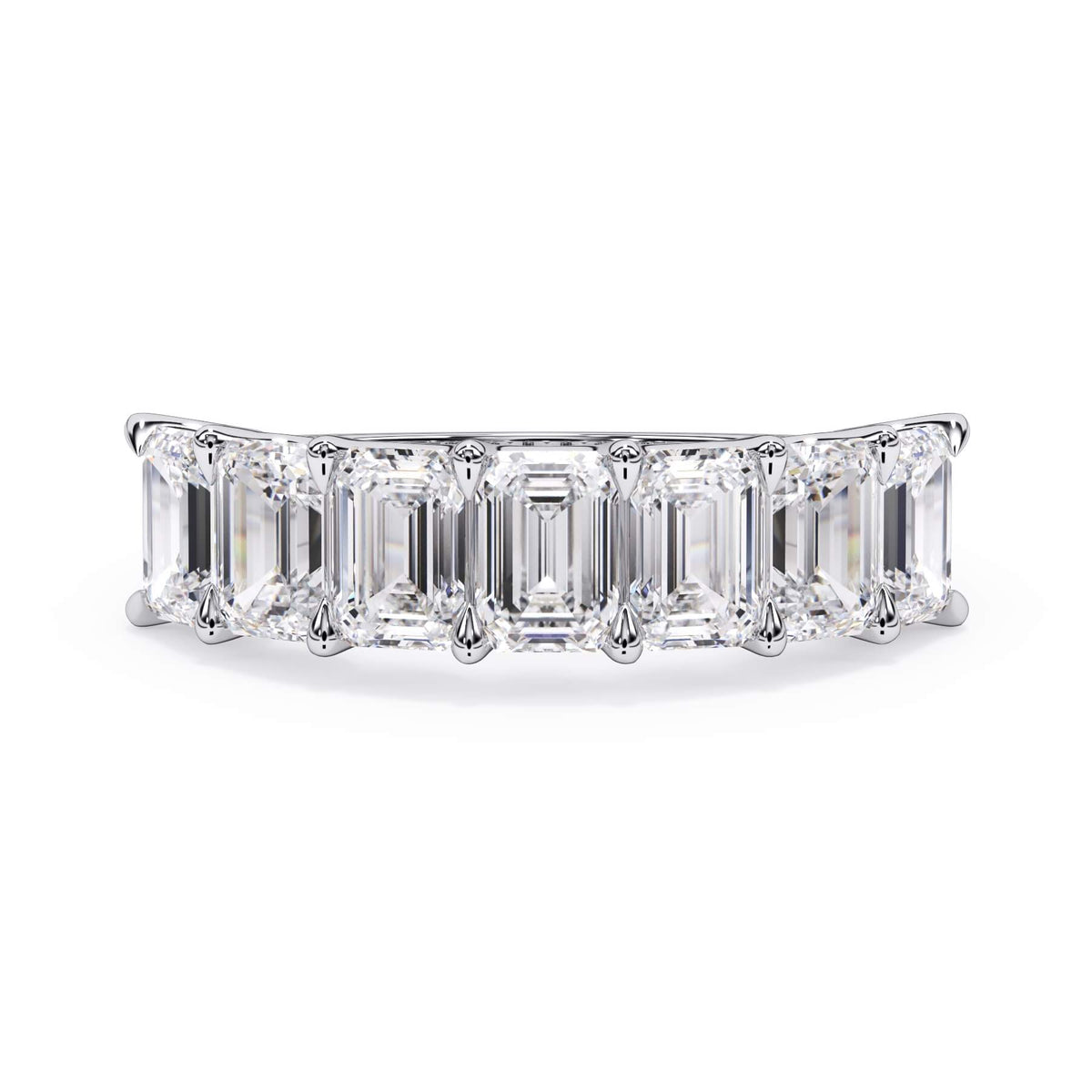 A picture of a seven stone diamond wedding ring with emerald cut diamonds that are U prong set in white gold or platinum on a white background with the ring facing forward, lying down.