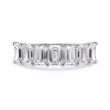 A picture of a seven stone diamond wedding ring with emerald cut diamonds that are U prong set in white gold or platinum on a white background with the ring facing forward, lying down.